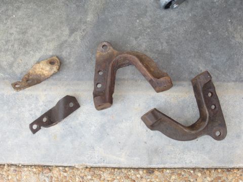 1992 Ford Bronco - Several assorted metal brackets are laid out on a concrete surface.