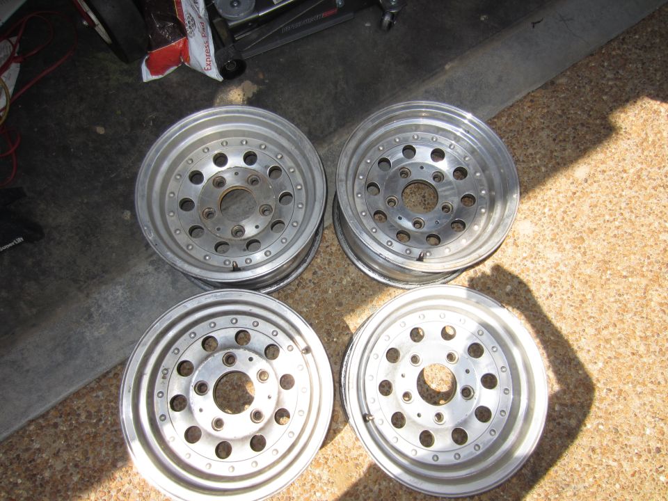 Four aluminum alloy wheels with multiple bolt holes