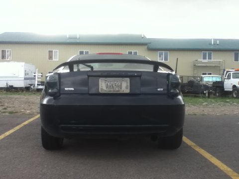 2006 Ford E350 - Rear view of a black Toyota Celica GT parked in a lot with other vehicles.