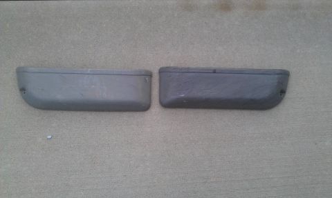 1991 Ford Festiva - Two grey bumperettes are shown against a concrete background. These appear to be aftermarket or replacement parts.