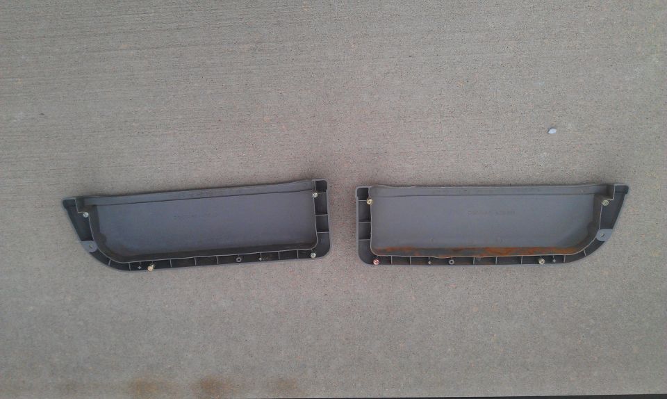 Two gray plastic car door panels with screw holes
