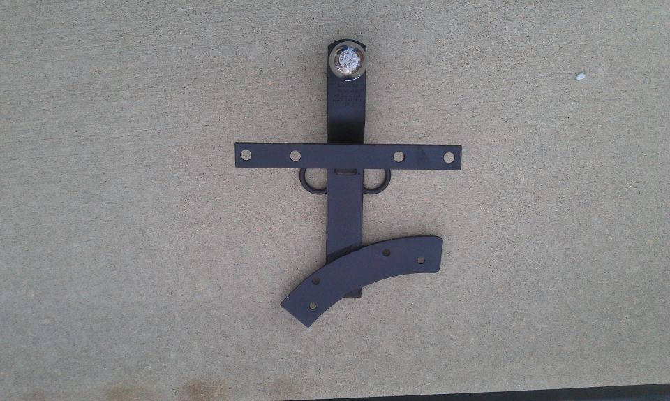 Black metal trailer hitch component with multiple holes and a curved piece