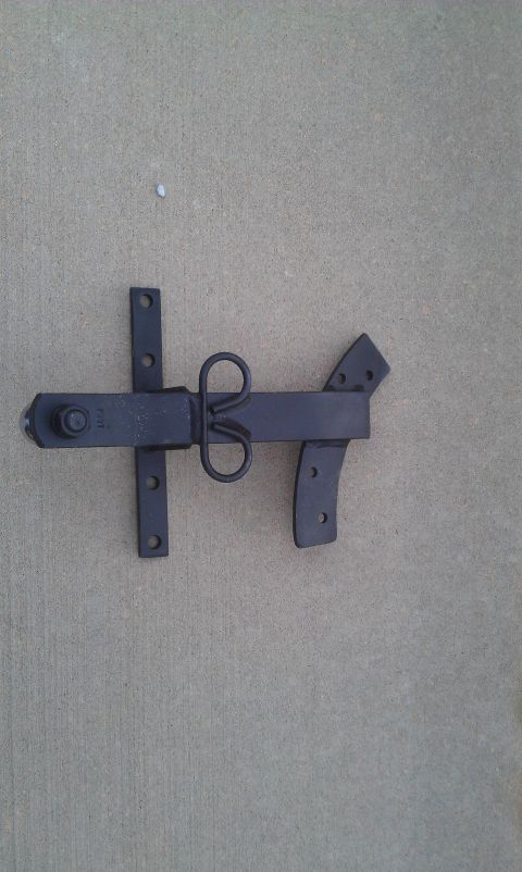 1991 Ford Festiva - A black metal gate latch is shown mounted on a concrete surface.