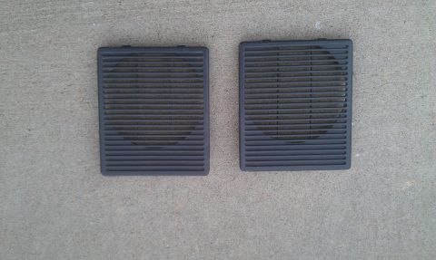 1991 Ford Festiva - Pair of black speaker grilles on concrete.