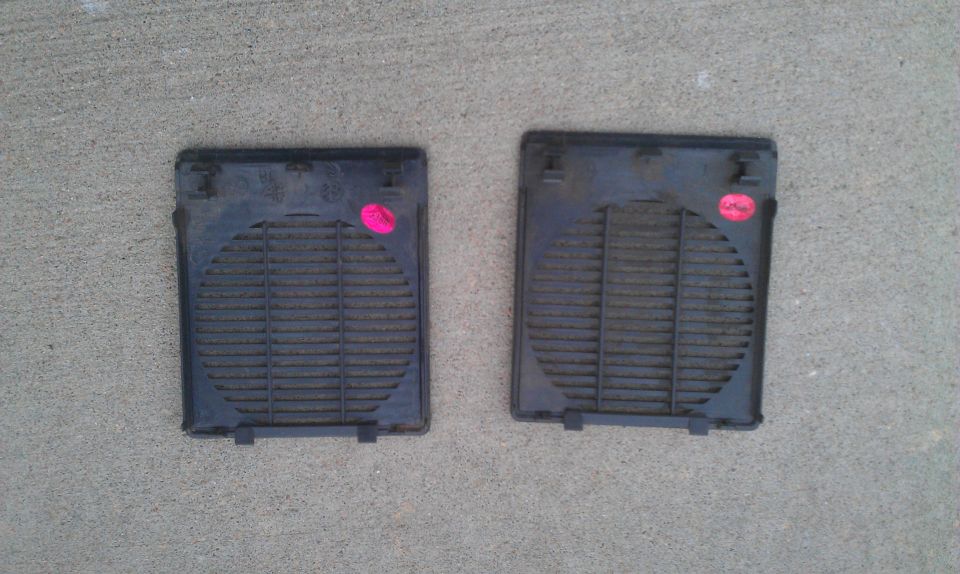 two black car speaker grilles with pink stickers on them