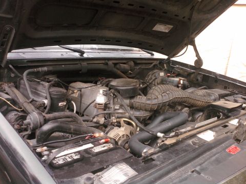 1994 Ford Bronco - Engine bay of a 1994 Ford Bronco, showing the V8 engine components and battery.
