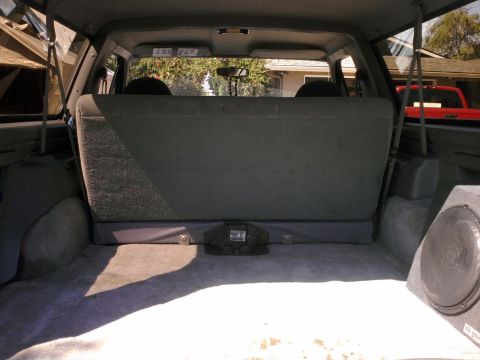 1994 Ford Bronco - The spacious interior of an SUV, showing the cargo area and a glimpse of the outdoors through the windows.