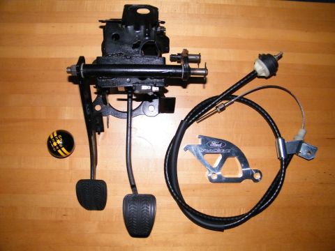 2004 Ford Crown Victoria - Manual transmission pedal assembly, Ford Racing bracket, and shifter knob shown on a wooden surface.