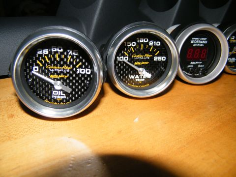 2004 Ford Crown Victoria - Close-up of aftermarket Auto Meter gauges including oil pressure, water temp, and air/fuel ratio.