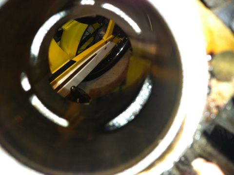 1981 Garelli Rally Sport - View through a pipe reveals a yellow motorcycle frame and wheel, possibly during a rebuild.