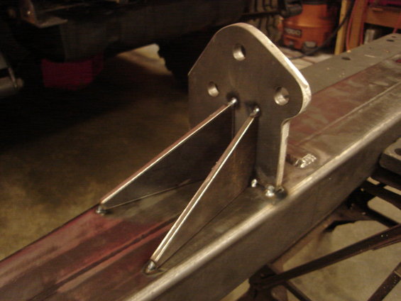 Welded metal bracket with three bolt holes attached to a steel frame