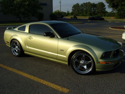 2007 Ford Mustang - A light green Ford Mustang GT is parked in a lot, showing its front three-quarter view.