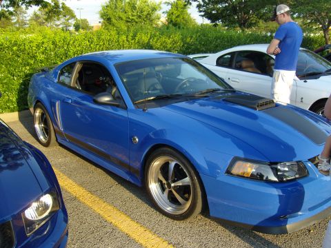2007 Ford Mustang - A bright blue 2007 Ford Mustang is parked next to another Mustang at a car meet.