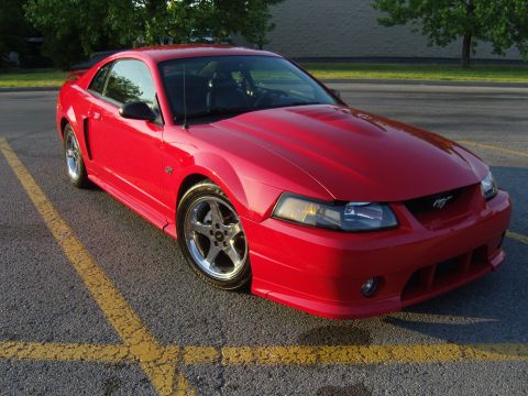 2007 Ford Mustang - Red Ford Mustang parked in a lot, front 3/4 view.