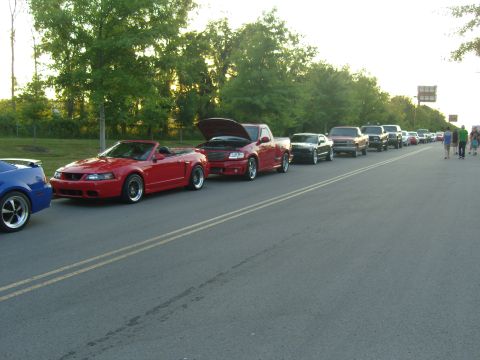 2007 Ford Mustang - A red 2007 Ford Mustang convertible is part of a car meet lineup.