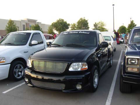 2007 Ford Mustang - Black Ford F-150 SVT Lightning pickup truck with custom grille and windshield banner.