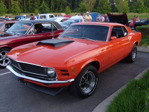 2007 Ford Mustang - A bright orange 1970 Ford Mustang is parked at an outdoor car meet.