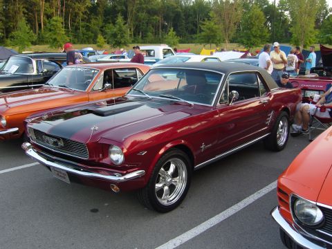 2007 Ford Mustang - Red 1965 Ford Mustang coupe parked at a car show with other vehicles.