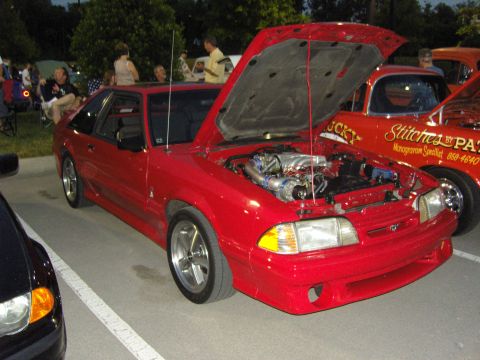 2007 Ford Mustang - A red Ford Mustang, likely from the early 90s, is displayed with its hood open, revealing a modified engine and turbocharger.