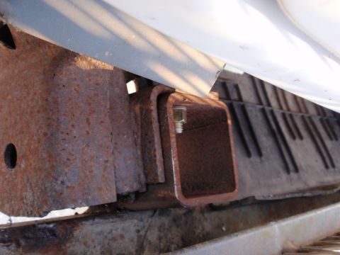 1995 Ford Bronco - Close-up view of a rusted vehicle frame with a trailer hitch receiver attached.