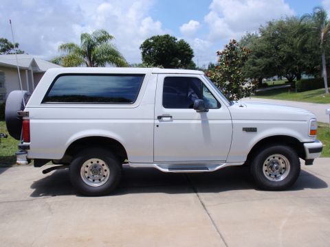 1995 Ford Bronco - This white 1995 Ford Bronco is shown from the side, a spare tire mounted on the back.