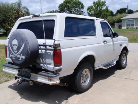 1995 Ford Bronco - Rear view of a white 1995 Ford Bronco, a spare tire cover with a pirate skull design.