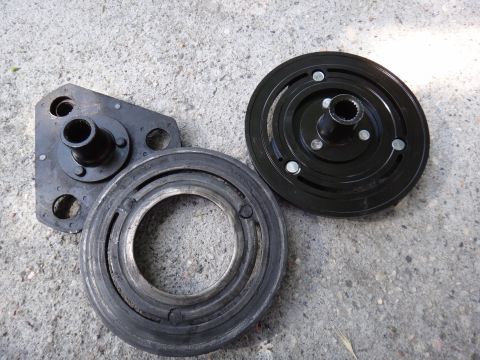 2003 Ford Taurus - Disassembled AC clutch hub components are shown on a textured concrete background.