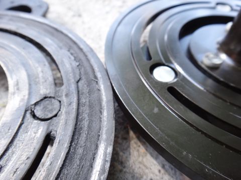 2003 Ford Taurus - Comparison of a worn AC clutch hub part next to a new one, highlighting the wear and tear on the older component.