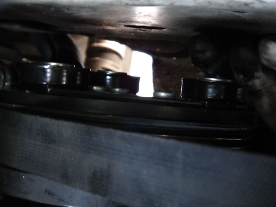 Close-up of an AC clutch pulley with multiple grooves and a serpentine belt