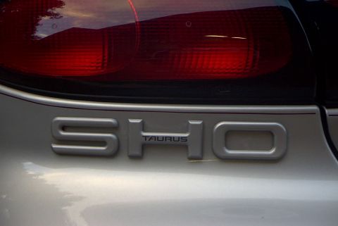 1998 Ford Taurus - The rear of a silver car displays the 'SHO TAURUS' badging, indicating a specific trim level.