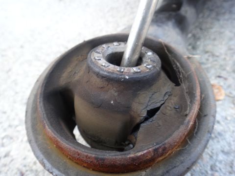 2003 Ford Taurus - This worn suspension bushing shows significant cracking and damage, indicating it needs replacement.