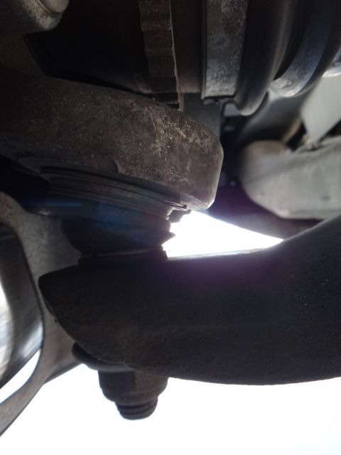 2003 Ford Taurus - Close-up of a vehicle's suspension components, showing a ball joint and control arm.