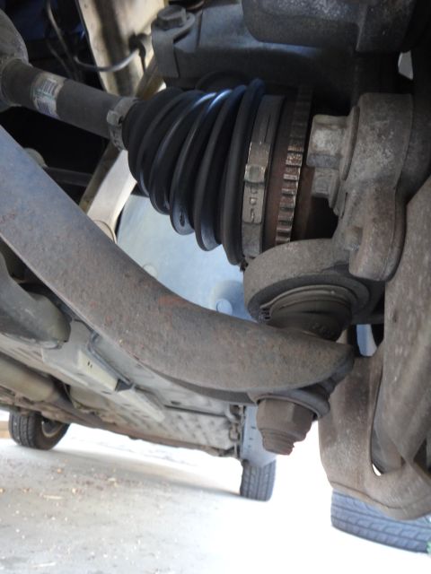 2003 Ford Taurus - Close-up view of the front suspension ball joint and CV axle boot on a vehicle.