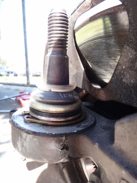 2003 Ford Taurus - A close-up view of a vehicle's ball joint assembly and a portion of the brake rotor.
