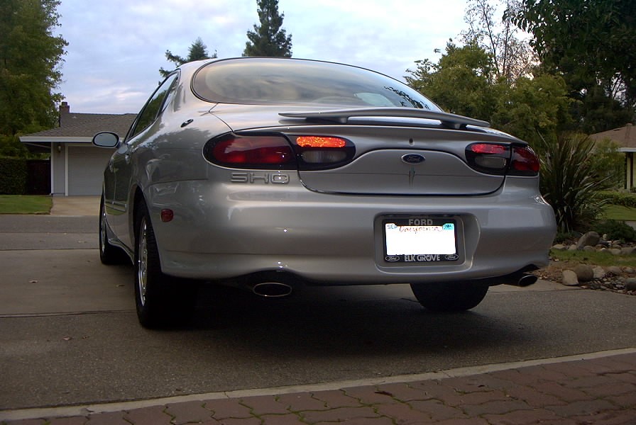 Rear view of a silver 1998 Ford Taurus SHO with a spoiler and dual exhaust pipes