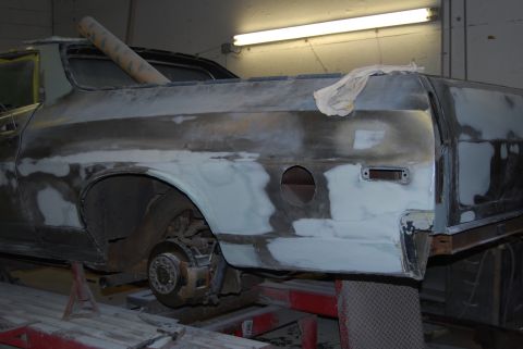1975 Ford Ranchero - A vehicle is undergoing bodywork, with primer and filler applied to the rear section.