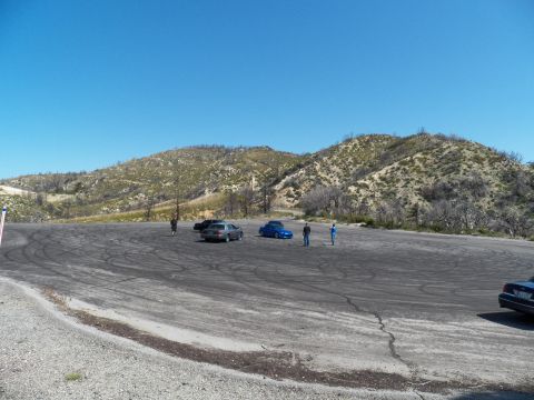 2003 Ford Crown Victoria - Wide view of a mountain pullout with parked cars and figures standing about