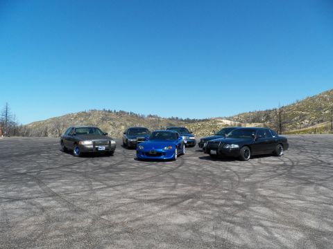 2003 Ford Crown Victoria - Cluster of cars on a mountain pullout with a blue roadster front and center
