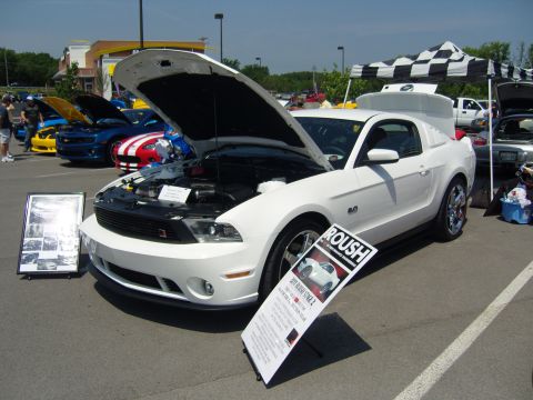 2007 Ford Mustang - A white Roush Mustang is displayed at a car show, with its hood open and information displayed on a sign.