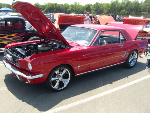 2007 Ford Mustang - A red classic coupe is displayed with its hood open at an outdoor car show.