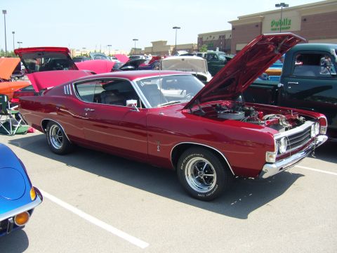 2007 Ford Mustang - A red 1970 Ford Torino coupe is displayed with its hood open at a car show.