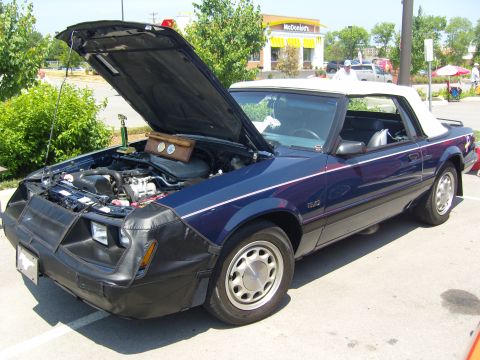 2007 Ford Mustang - A blue convertible Mustang is parked outside with its hood open, revealing the engine compartment.