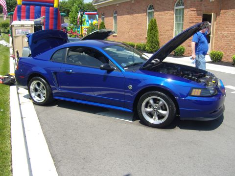 2007 Ford Mustang - A blue Ford Mustang is parked with its hood open, showing the engine compartment.