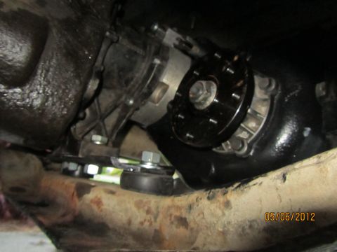 1984 Ford Bronco - Underside view of a vehicle's drivetrain, showing the transfer case and a black adapter plate.