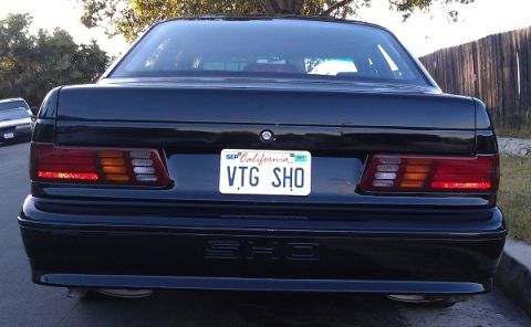 1991 Ford Taurus - Rear view of a black 1991 Ford Taurus SHO, showing its distinctive taillights and license plate.