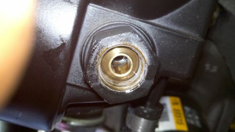 1978 Ford Bronco - A close-up view of a metal fitting, likely a component from a larger assembly, with visible wear and residue.