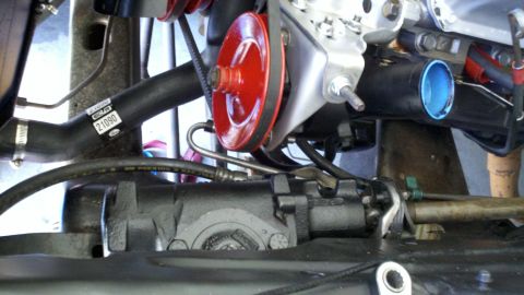 1978 Ford Bronco - Close-up view of engine components, including a red pulley and a black hose with part number 21090 visible.