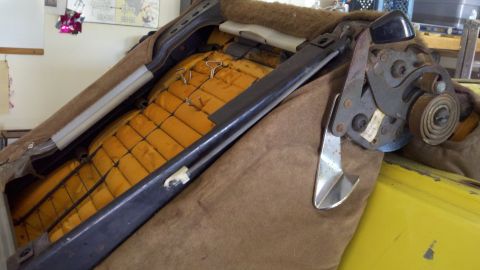 1978 Ford Bronco - The internal workings of a car seat, showing the metal frame, springs, and yellow padding.