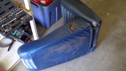 1978 Ford Bronco - A blue car seat is shown with a toolbox and storage bins in the background.