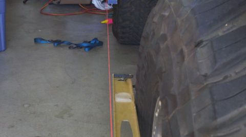 1978 Ford Bronco - Alignment equipment and a large tire are visible in a garage setting.